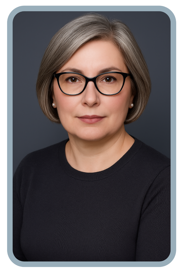 A woman with short grey hair and glasses sits with her arms crossed, looking directly at the camera.